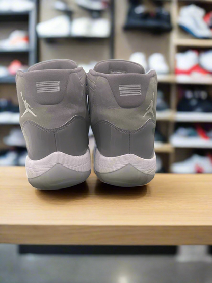 Pair of gray sneakers with a white logo on a white platform.