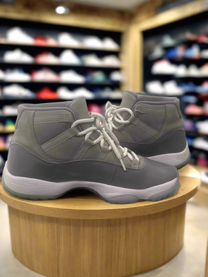 Gray high-top sneakers on a Nike box with a white wall background