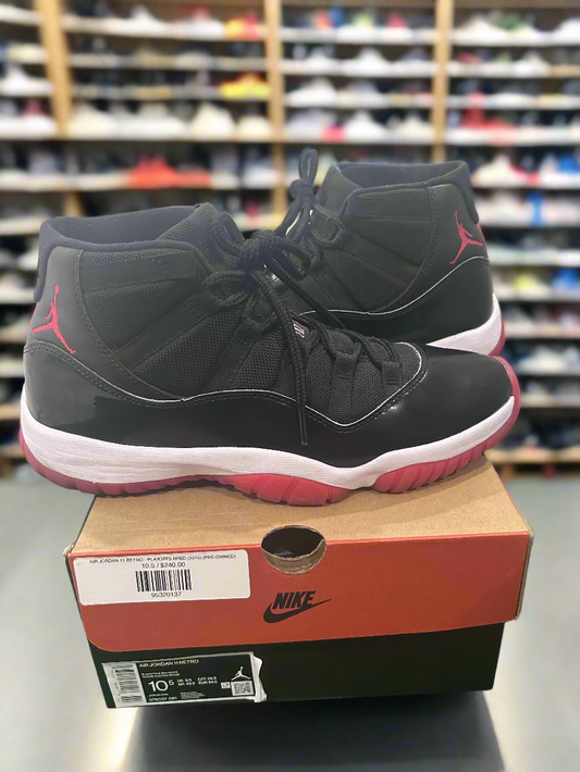 Black and red high-top sneakers on a Nike box with a store shelf in the background